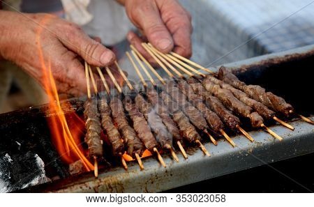 Hands Of Cook While Cooking Mutton Skewers Called Arrosticini In The Language Of Southern Italy