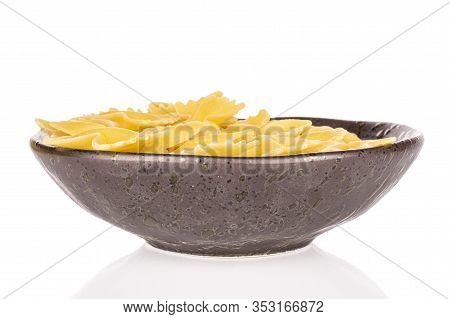 Lot Of Whole Yellow Pasta Farfalle In Glazed Bowl Isolated On White Background