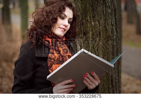 Portrait Of A Beautiful Blue-eyed Girl Reading A Book Close-up.