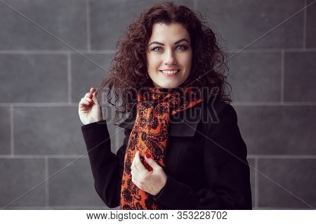 A Beautiful Girl Smiling Adjusts Her Long Curly Hair