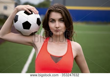 girl-football player in top and shorts on the football field