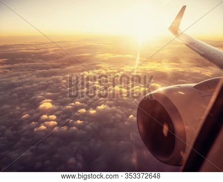 View On Airplane Wing In Sunset Time Over A Clouds