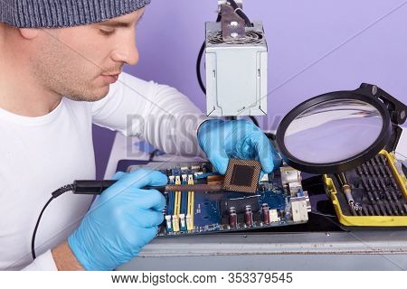 Close Up Portrait Of Concentrated Technician Man Rapairing Broken Computer Motherboard, Man Wearing 