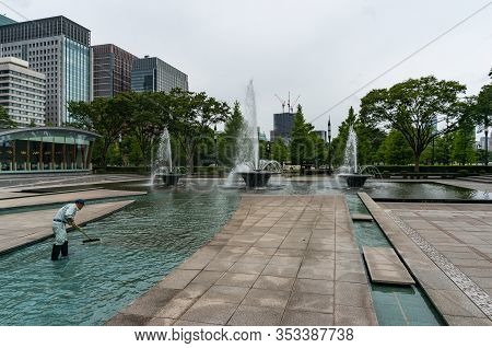 Tokyo, Japan - August 30, 2016: Person Cleaning Wadakura Fountains In Marunouchi Suburb Of Tokyo, Ja
