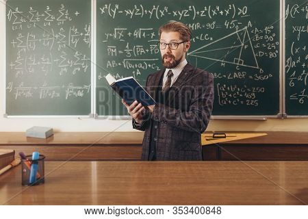 Bearded Professor In Suit And Glasses Citing A Manual