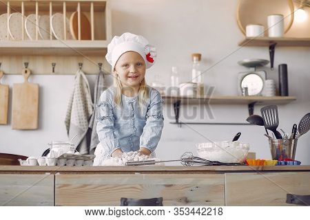 Little Girl In A White Shef Hat Cook The Dough For Cookies