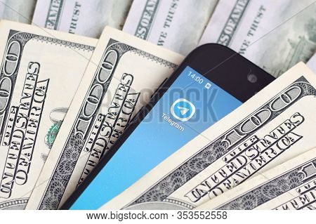 Smartphone Screen With Telegram App And Lot Of Hundred Dollar Bills. Business And Social Networking 