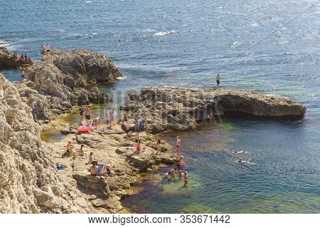 Tarkhankut, Crimea, Russia-september 11, 2019: People Swim At Cape Tarkhankut. Stone Spurs At The We