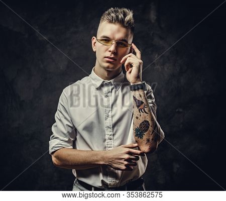 Extravagant And Inked Hipster Male Model Posing In A Studio Wearing A White Shirt, Yellow Glasses, S