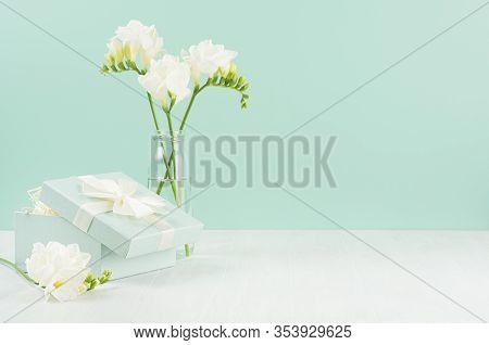 Romantic Bright Holiday Background With Spring Flowers Freesia In Glass Vase And Ajar Gift Box With 