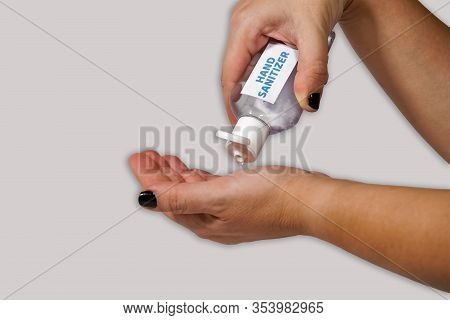 Cleaning Hands With Waterless, Alcohol-based Hand Sanitizer Antiseptic Gel. Female Holds A Bottle Fo