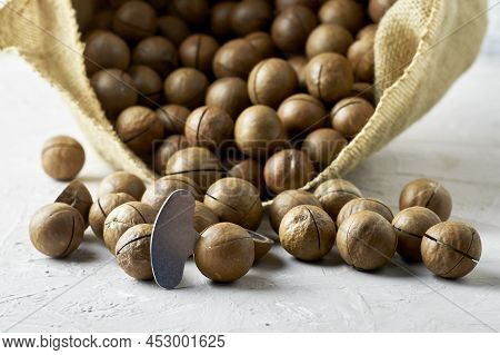 Canvas Bag With Macadamia Nuts Close-up And A Key For Cracking Nuts Stuck In A Nut