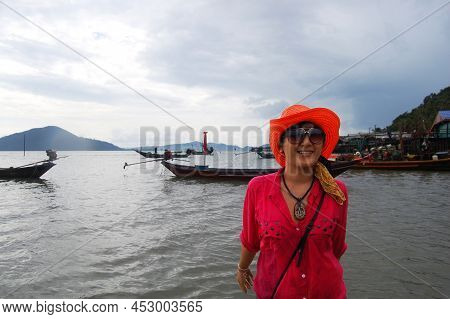 Traveler Thai Women Playing Water In Sea Ocean On Eastern Shore Of The Gulf Of Thailand While Rainin