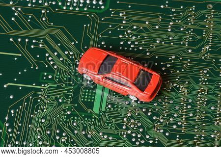 Toy Cars On An Electronic Board With Integrated Circuits. The Shortage Of Microchips And Semiconduct