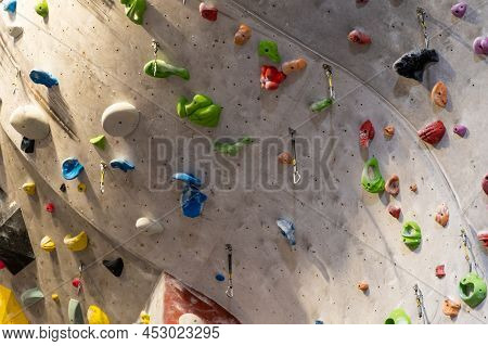Artificial Rock Climbing Wall With Various Colored Grips.
