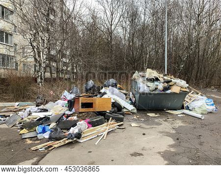 Large Metal Trash Can Full Of Garbage Polluting The Street In The City. Disposal Of Domestic Househo