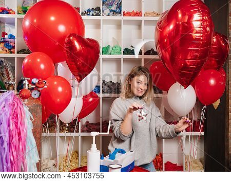Woman With Red Ball Of Foil In Shape Of Heart And Cargo In Shape Of Silver Star.