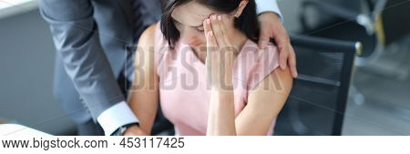 Businessman Pestering Female Colleague In The Workplace. Harassment At Work Concept