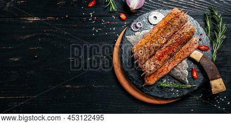 Raw Lula Kebab On Skewers With Spices Dark Background. Lula Kebab, Traditional Caucasian Dish. Long 