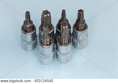 Set Of The Interchangeable Torx Bits Different Sizes For Screwdriver On A Blue Surface Close-up
