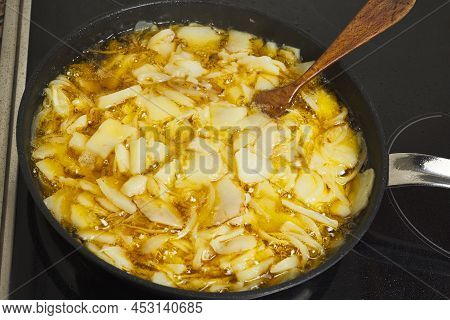 Preparing An Omelette. Frying Potatoes And Onions In A Pan