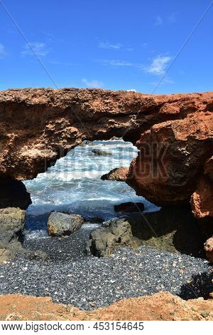 Looking Through A Natural Bridge Along The Coast Of Aruba.