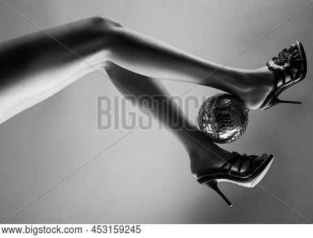 Sexy Legs. Disco Party. Woman Legs With Gold Disco Ball. Celebrate Concept. Gold Disco Ball On High 