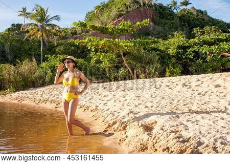 Fit Women In A Yellow Bikini At The Beach Known As Pitinga, In Arraial D\' Ajuda, Bahia, Brazil