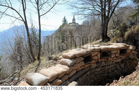 Long Trench Dug Into The Rock By Army Soldiers During The War With Sandbags For Defense And The Monu