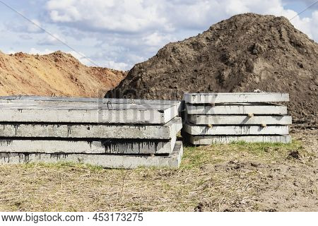 Reinforced Concrete Slabs At A Construction Site Against A Blue Cloudy Sky And Earth. Folded Plates 