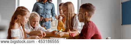 Happy Boys And Girls Using Wooden Math Tablet