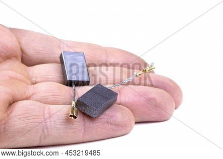 Carbon Brushes In Hand Isolated On A White Background. Brushes For Electric Motor.spare Parts For An