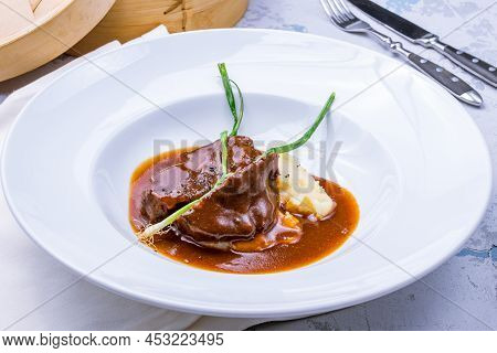 Beef Cheeks With Mashed Potatoes And Sauce Demiglass On Plate