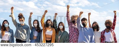 Panoramic Image Of Multiracial Activist Protesters With Fists Raised Up In The Air Wearing Face Mask