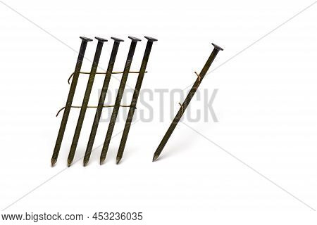 Close Up Of A Group In A Row Of Wire Connected Special Nails Next To A Detached Single Wire Nail For