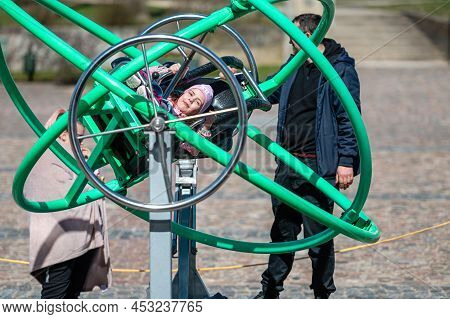 Dobele, Latvia - April 17, 2022: Kids Enjoy The Extreme Attraction Aerotrim - A Human Gyroscope With