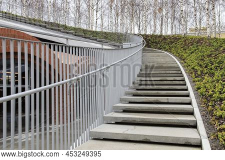 Tall Modern Winding Staircase With Railings In A Birch Grove