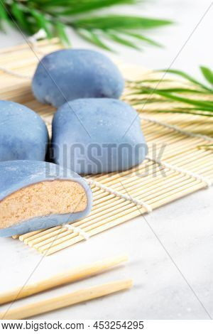A Japanese Rice Cake Lying On A Wooden Mat On White Countertop. Concept Of A Traditional Japanese Mo