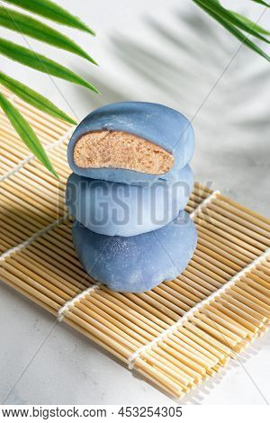 A Small Tower From Rice Cakes On A Wooden Mat. Concept Of A Traditional Japanese Mochi With Blue Mat