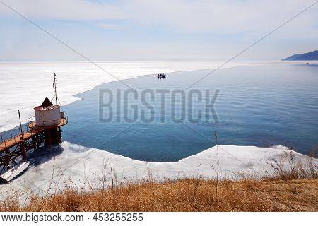 Lake Baikal In Spring. A Hovercraft Transports Tourists From The Village Of Listvyanka. Ice Floes An