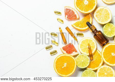 Vitamin C. Anti Aging Cosmetic. Fresh Citrus Fruits With Serum Bottles, Ampoules And Pills. Top View