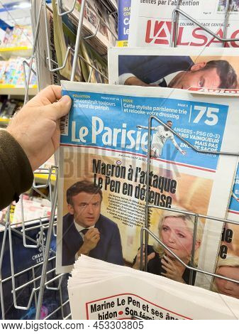 Paris, France - Apr 21, 2022: Pov Male Hand Buy Le Parisien Newspaper Press Headlines After Debate B