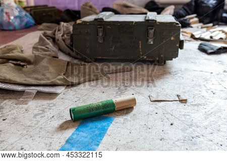 Barmashovo, Ukraine- March 18, 2022: Dirt and trash, garbage and woden boxes with weapons and smoke 