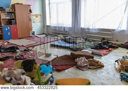 Barmashovo, Ukraine- March 18, 2022: Dirt and trash, garbage with mat in half-destroyed school room 