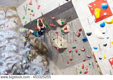 The Climber Trains On The Artificial Rock Wall With Insurance In Bouldering Gym, April 2022, Prague,
