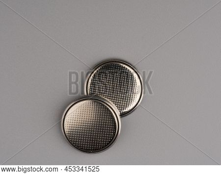 Round Batteries On A Gray Background. Closeup