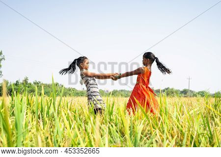 Young Teenager Girl Kids Playing In The Middle Of Paddy Field During Harvesting Season - Concept Of 