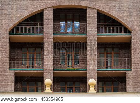 Many Balconies And Windows In A Row On The Facade Of The Modern Urban Apartment Building Front View,