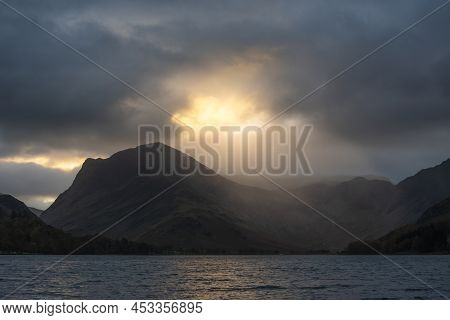 Stunning Autumn Sunrise Landscape Image Of Buttermere In Lake District With Dramatic Stormy Sky