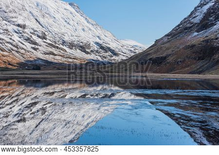 Beautiful Winter Landscape Image Of Loch Achtriochan In Scottish Highlands With Stunning Reflections